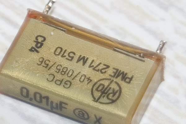 A close-up shot of an X2 capacitor showing the hairline cracks in the case
